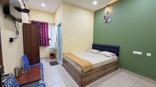 a bedroom with a bed in a green wall at Gravity Groups Core VHR Residency in Puducherry Airpoert