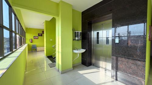 a bathroom with green walls and a sink at Gravity Groups Core VHR Residency in Puducherry Airpoert