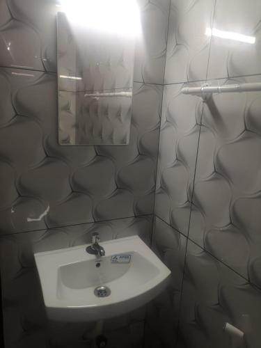 a bathroom with a sink and a mirror at Railviewtouristhome in Varkala