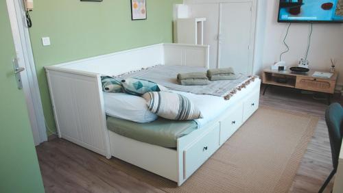 a white bed with pillows on it in a bedroom at Le Cocon Bressan hyper centre & lumineux in Bourg-en-Bresse