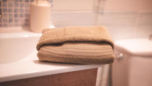 a pile of towels sitting on a counter in a bathroom at Le Cocon Bressan hyper centre & lumineux in Bourg-en-Bresse