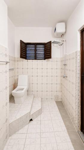 a bathroom with a toilet and a window at Serene Abodes in Zanzibar City