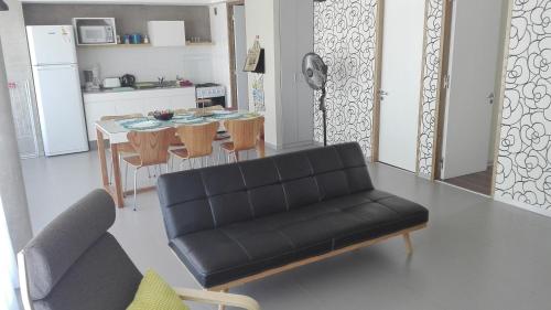 sala de estar con sofá negro y cocina en Marina Piccola en Ostende