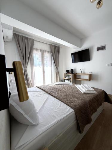 a bedroom with a large bed and a television at ThasosGoldenStay in Skala Potamias