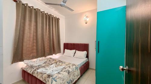 a bedroom with a bed and a green door at Krishna Cottage 3BR Apt By Amoret Homes in Chicalim