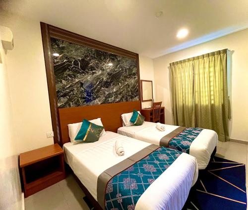 a hotel room with two beds and a window at Near Jonker Street - JCITYHOTEL - FREE PARKING in Malacca