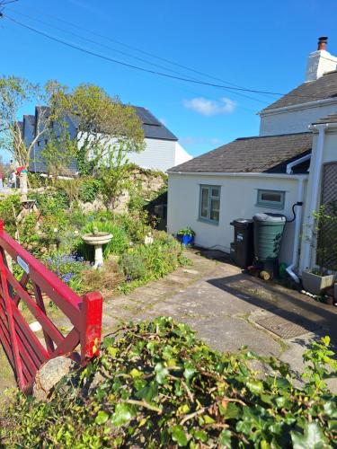 a red bench in front of a house at Redmoor in Saint Day