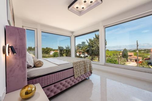 a bedroom with a bed and large windows at Villas Weiss in Vir