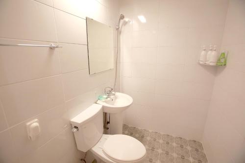 a white bathroom with a toilet and a sink at 마음스테이 in Taesuha-dong