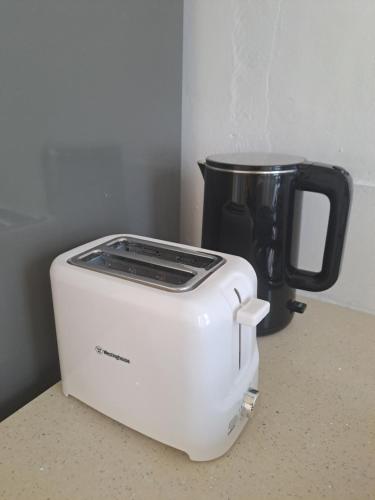 a white toaster sitting on a counter next to a coffee pot at Authentic South in Mahébourg