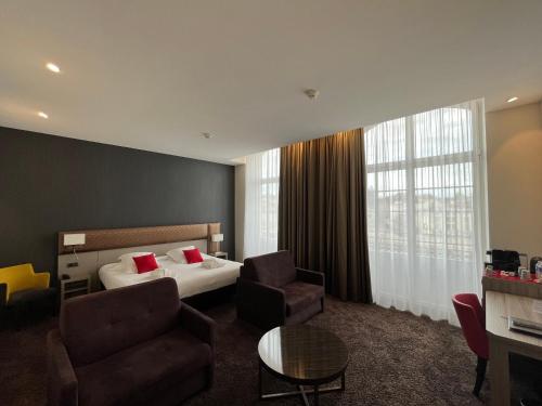 a hotel room with a bed and a desk at Les Jardins du Mess in Verdun-sur-Meuse