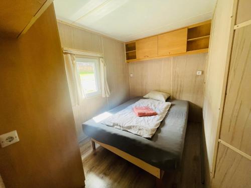 a small bedroom with a bed in a tiny house at Mobilheim Luna - Výrovická přehrada in Výrovice