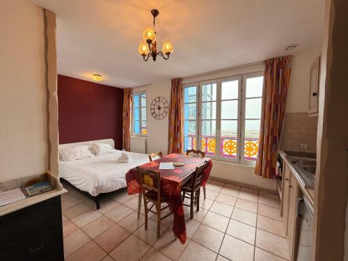 a bedroom with a table and a bed and a table and chairs at Ets Levillain - Hôtel Les Calètes in Le Tréport