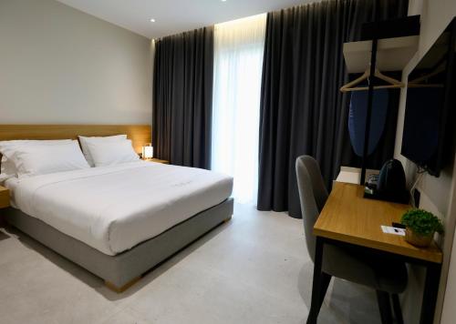 a hotel room with a bed and a desk and a desk at Niklas Boutique Hotel in Sarandë