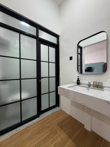a bathroom with a sink and a mirror at And Living Hotel in Kejayan