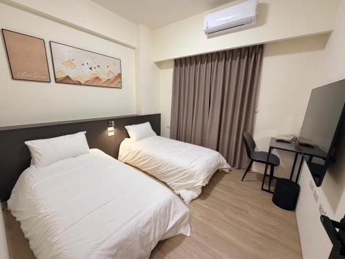a hotel room with two beds and a desk at Si Sou Homestay in Nanxi