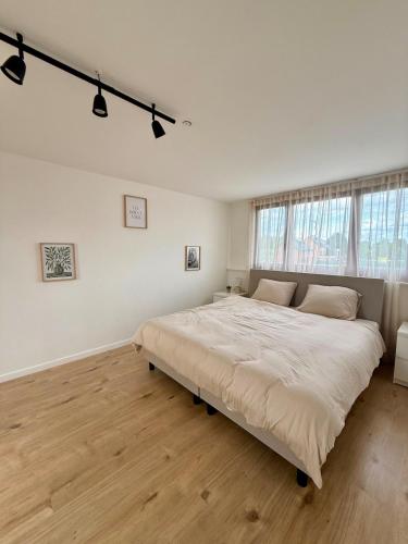 a large white bedroom with a large bed in it at Het Schuttershof in Hoogstraten