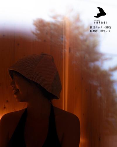 a woman wearing a hat in front of a wall at 軽井沢一棟貸しBBQサウナつき別荘- YURAGI - TSUKI me CHILL in Miyota