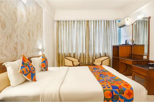 a hotel room with a bed and a desk at FabHotel Golden Emerald in Pune