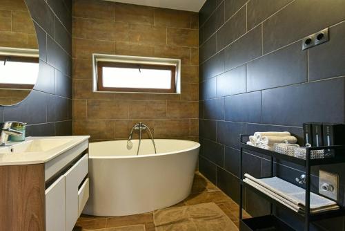 a bathroom with a tub and a sink at Luxbor Villa in Eger