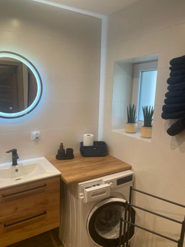a bathroom with a washing machine and a sink at Agroturystyka u Iwony in Wiekowo