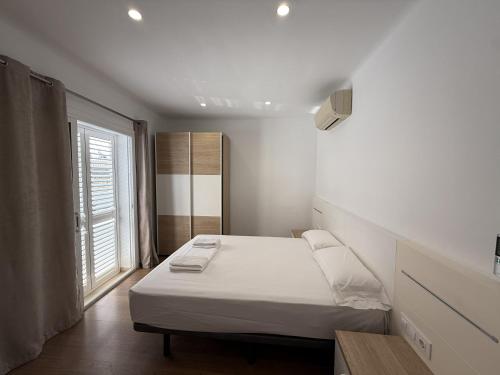 a small bedroom with a bed and a window at Apartament Blau Marí in Roses