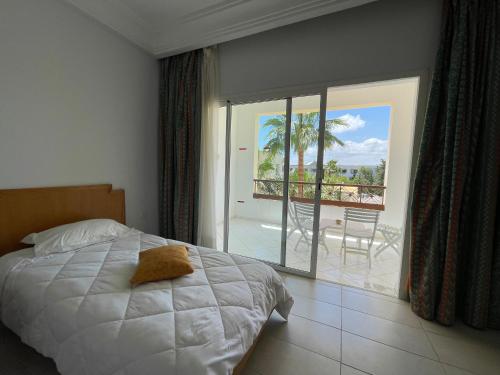 a bedroom with a bed and a view of a balcony at Marina Palace in Hammamet