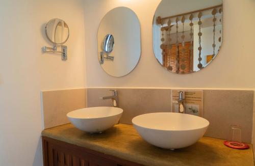 a bathroom with two sinks and mirrors on a counter at Belamandy Lodge Hotel au luxe simple in Anjramarango