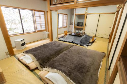 a bedroom with a large bed in a room with windows at Ichimaru Ryokan - Vacation STAY 59281v in Tenkawa