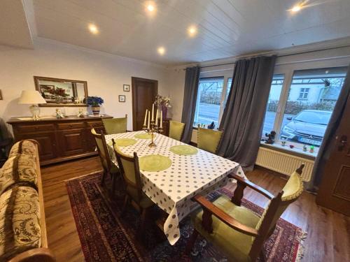 a dining room with a table and a couch at EifelRuhe 2 - Komfortable Ferienunterkunft für bis zu 10 Gäste mit 4 Schlafzimmern, großer Küche und genug Parkplätzen - ideal für Gruppen und Familien, Hunde zulässig in Losheim