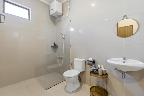a bathroom with a toilet and a sink and a shower at KAUH House Canggu in Tumbak Bayuh