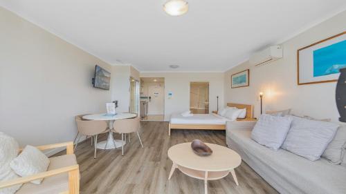 a living room with a couch and a table at Studio Oasis - Ettalong Beach Resort in Ettalong Beach