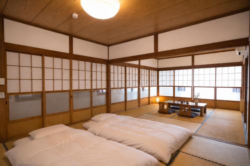a room with two beds in a room with windows at 富士と宿と Fuji to Yado to in Fujiyoshida