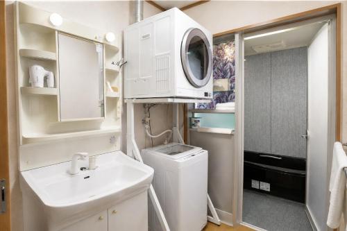 a bathroom with a sink and a washing machine at 富士と宿と Fuji to Yado to in Fujiyoshida