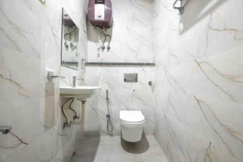 a white bathroom with a toilet and a sink at FabHotel Dwarka Heritage in New Delhi