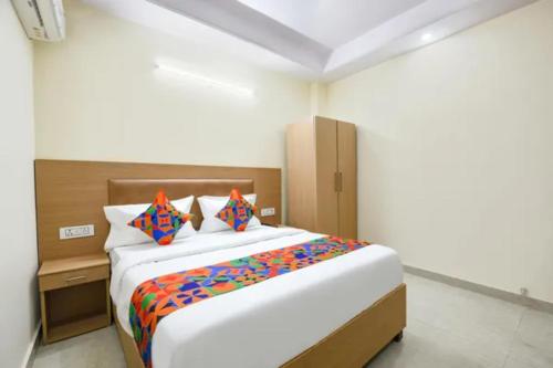 a bedroom with a large bed with colorful sheets at FabHotel Dwarka Heritage in New Delhi