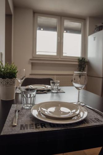 a table with a plate and wine glasses on it at Apartment Claussen 2 in Bremerhaven