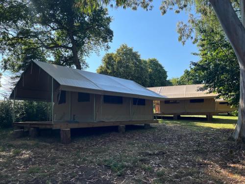 a large green building with a tin roof at Camping Onlycamp les etangs in La Richardais