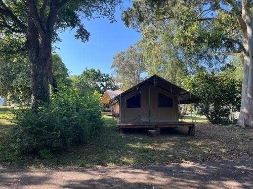 a small tent sitting in a field next to trees at Camping Onlycamp les etangs in La Richardais