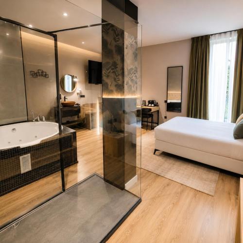 a bedroom with a bed and a bathtub and a bed and a bathroom at Saman Hotel Boutique in Valencia