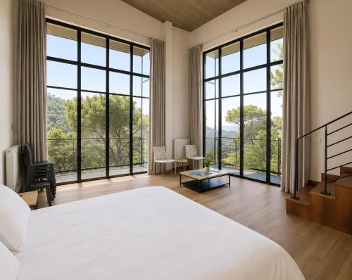 a bedroom with a large bed and large windows at The Silk Valley in Arşūn