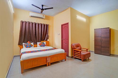 a bedroom with a bed and a chair at FabHotel Nimalan Residency Tambaram in Chennai