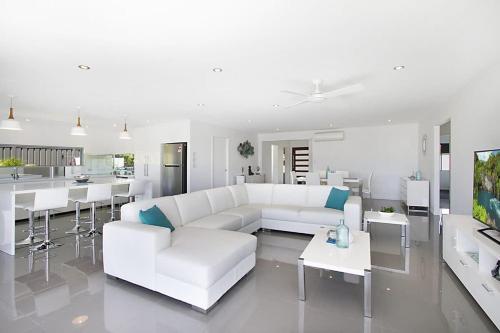a white living room with a white couch and tables at Buena Vista in Gold Coast