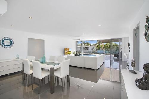 a dining room and living room with a table and chairs at Buena Vista in Gold Coast