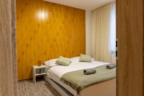 a bedroom with a bed and a wooden wall at Penzión Stálica in Bojnice