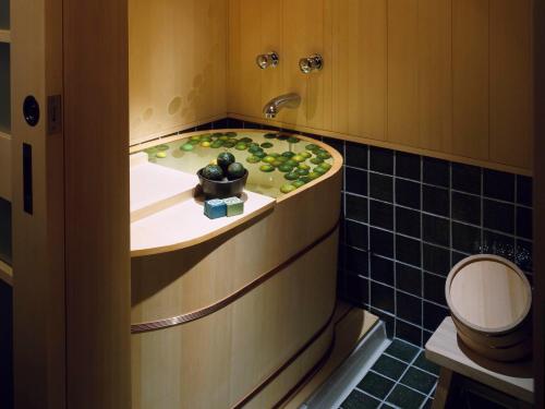 a bathroom with a sink with green fruit on it at Yuzuya Ryokan - Adult Only in Kyoto