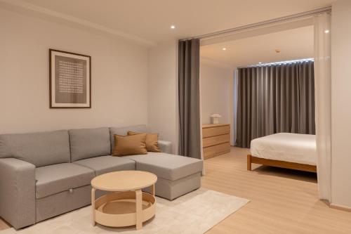 a living room with a couch and a bed at Taupe Hotel in Chiang Mai