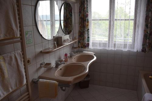 a bathroom with two sinks and a mirror at Hotel Gasthof Straub in Lenzkirch