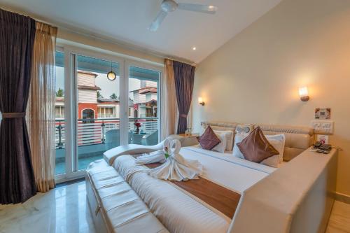 a bedroom with a large bed with a large window at Hotel Shanti Solitaire, Arpora in Arpora