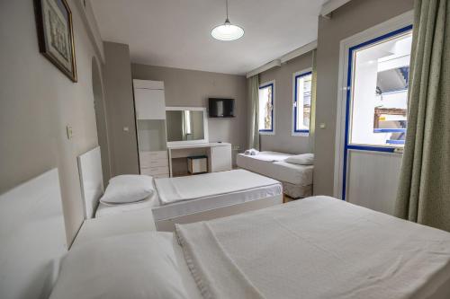 a hotel room with two beds and a window at Sunpoint Hotel Bodrum in Bodrum City